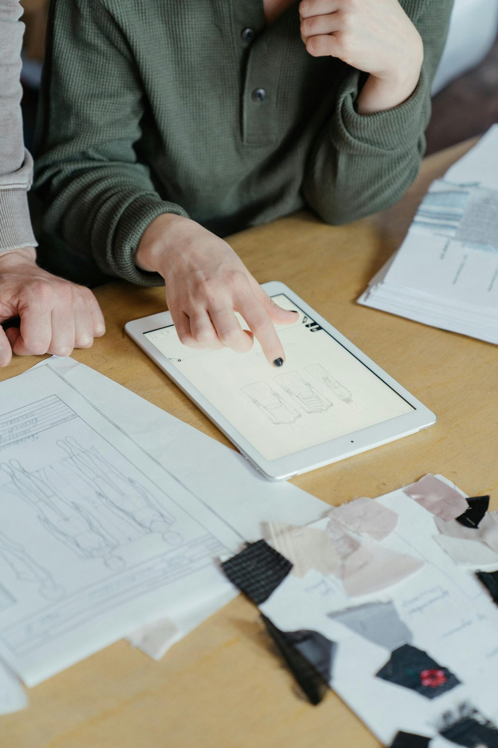 Designers collaborate using digital sketches on a tablet in a creative workspace.